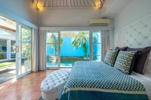 Un dormitorio con una cama y una ventana grande. en THE CABANA, en Sanur