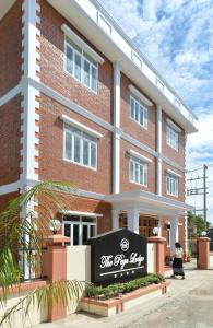 un edificio de ladrillo rojo con un cartel delante en The Pegu Lodge en Bago