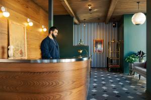 a man standing at the counter of a restaurant at Palihotel Culver City in Los Angeles