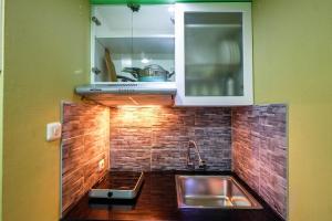 a kitchen with a sink and a microwave at Strategic Studio The Oasis Cikarang near Omni Hospital By Travelio in Cikarang +6 photos