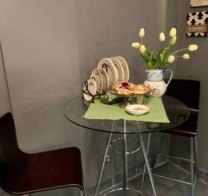 una mesa con un plato de comida y un jarrón con flores en GREY GARDENS HAMILTON Instant Hotel & Guest House, en Hamilton
