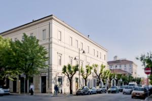 ein großes weißes Gebäude mit Autos auf einer Straße in der Unterkunft Dimora Novecento in Pescara