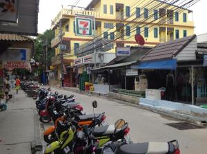 una fila di motociclette parcheggiate sul lato di una strada di Baan Mulan a Ko Samed
