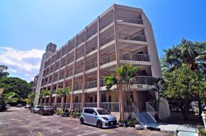 バトゥ・フェリンギにあるHome stay Bayu Emas Appartment, Batu Ferringhiの建物の前の駐車場に駐車された車