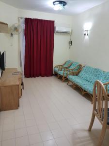 バトゥ・フェリンギにあるHome stay Bayu Emas Appartment, Batu Ferringhiのベッド2台と赤いカーテンが備わる客室です。