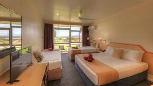 a hotel room with two beds and a tv at Atherton Motel in Atherton