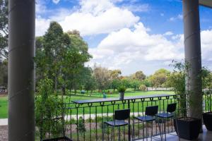 a view of a park from a balcony with chairs at Sfera's Park Suites & Convention Centre in Adelaide