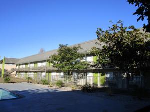 an office building with a fence in front of it at SureStay Plus Hotel by Best Western Point Richmond in Richmond