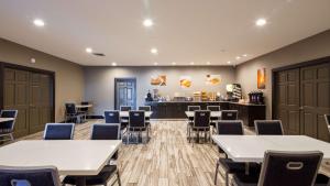 a waiting room with tables and chairs and a counter at SureStay Plus Hotel by Best Western Point Richmond in Richmond