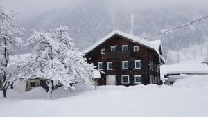 ein schneebedecktes Haus vor der Tür in der Unterkunft Haus Mair in Gaschurn