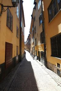 una calle vacía en un casco antiguo con edificios amarillos en Executive Living Old Town Unique, en Estocolmo