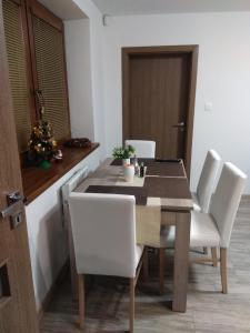 a dining room with a table and white chairs at Apartmány Danka in ľubeľa