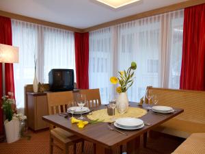 奧伯古格爾的住宿－安克格和芭芭拉公寓，用餐室配有木桌、盘子和玻璃杯