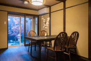 Un comedor con mesa y sillas de madera. en Kyomachi Rakunan, en Kioto
