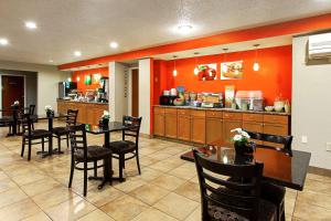 a restaurant with tables and chairs and a kitchen at Quality Inn Plainfield I-395 in Plainfield
