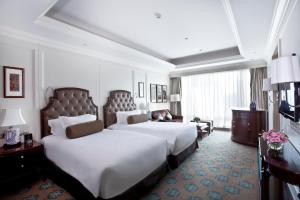 um quarto de hotel com duas camas e um sofá em The Langham, Shenzhen em Shenzhen