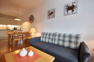 ein Wohnzimmer mit einer blauen Couch und einem Tisch in der Unterkunft Seepark Sellin - Apt. 635 in Ostseebad Sellin + 12 Fotos