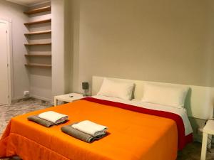 a bedroom with an orange bed with two towels on it at CAVOUR 124 -guest-room- in Bari