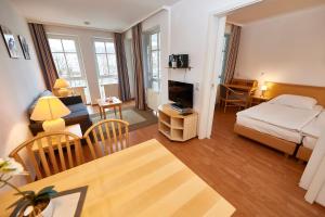 ein kleines Wohnzimmer mit einem Bett und ein Wohnzimmer mit einem Sofa in der Unterkunft Seepark Sellin - Apt. 635 in Ostseebad Sellin