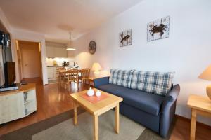 ein Wohnzimmer mit einer blauen Couch und einem Tisch in der Unterkunft Seepark Sellin - Apt. 635 in Ostseebad Sellin