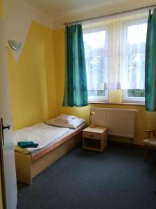 niewielka sypialnia z łóżkiem i oknem w obiekcie Hotel Modrá hvězda Sadská w mieście Sadská