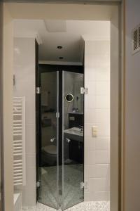 a bathroom with a glass shower and a sink at Hotel Savoy Hannover in Hannover