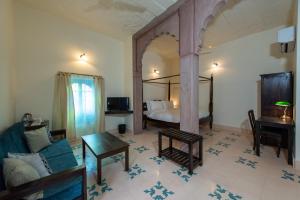 una habitación con una cama y un sofá y una mesa en Baijoo Niwas, en Jodhpur