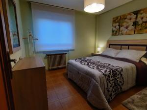 a bedroom with a bed and a large screen at LA LAGUNA in Laguna de Duero