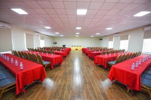 une salle de banquet avec des tables rouges, des chaises et un tissu de table rouge dans l'établissement Nyumbani Hotel, à Kampala