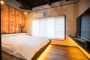 een slaapkamer met een bed en een groot raam bij Kyomachi Hoshizuki in Kyoto