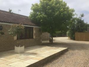 a house with a tree next to a driveway at Self Contained Holiday Home Caravan in Corsham
