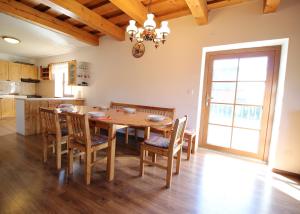 Il comprend une cuisine et une salle à manger avec une table et des chaises en bois. dans l'établissement Chata u Mikiho Krahule, à Krahule
