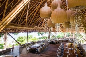 a restaurant with tables and chairs in a straw roof at Bawah Reserve in Mampo