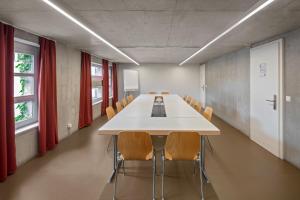 une longue salle de conférence avec une grande table et des chaises dans l'établissement Lausanne Youth Hostel Jeunotel, à Lausanne