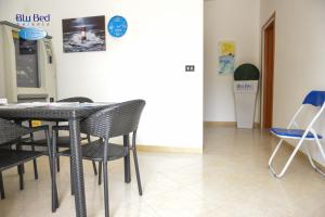 a table and chairs in a room with a refrigerator at Blu Bed Salento in Torre Lapillo