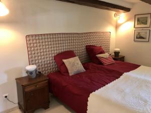 una camera da letto con letto con lenzuola e cuscini rossi di MORTZI villa 4 étoiles avec piscine a Mortzwiller