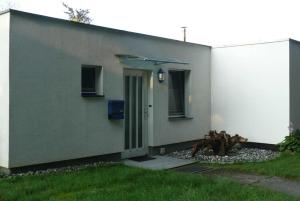 ein grünes und weißes Haus mit einer Tür in der Unterkunft Ostsee Bungalow Stolteraa _ Objekt in Diedrichshagen