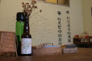 una bottiglia di vino seduta su un tavolo accanto a un muro di Mountain Lodge Hostel a Nanzhuang