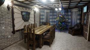 a dining room with a table and a christmas tree at Берлога 2 in Mykulychyn