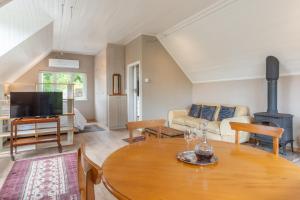 a living room with a table and a wood stove at The Coach House at Hillwood in Cape Town