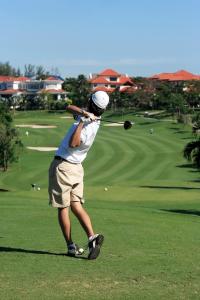 a man swinging a golf club on a golf course at Hotel Nautico in Santa Cruz de Tenerife