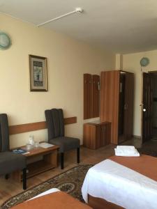 una camera d'albergo con due letti e un tavolo con sedie di Hotel Triumph a Brăila
