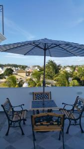 einen Tisch und Stühle unter einem Sonnenschirm auf einer Terrasse in der Unterkunft Krishangel Beach Apartment in Flic-en-Flac