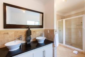 a bathroom with two sinks and a large mirror at Infinity Blue Luxury Accommodation in Wilderness +78 photos