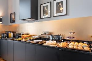 a buffet line with various types of bread and pastries at The White Box Boutique House in Porto