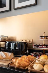 a table with breads and a toaster on a counter at The White Box Boutique House in Porto