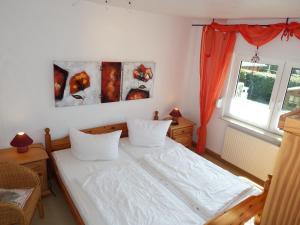 a bedroom with a white bed and a window at Strandmensch Dornumersiel in Dornum