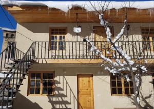Casa bianca con scale e balcone di Guesthouse Robi a Mestia