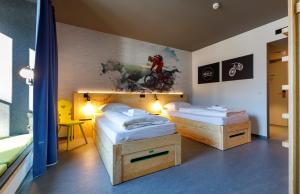 ガルミッシュ・パルテンキルヒェンにあるDJH moun10 Jugendherberge - membership required!のベッドルーム1室(ベッド2台付)が備わります。壁には絵画が飾られています。