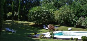 una piscina en un patio con 2 sillas de césped en La Lilas des Fargues Maison d'Hôtes, en Albi